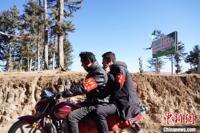 圖為同事騎摩托車載著桑杰加(后)前往林場(chǎng)?！●R銘言 攝