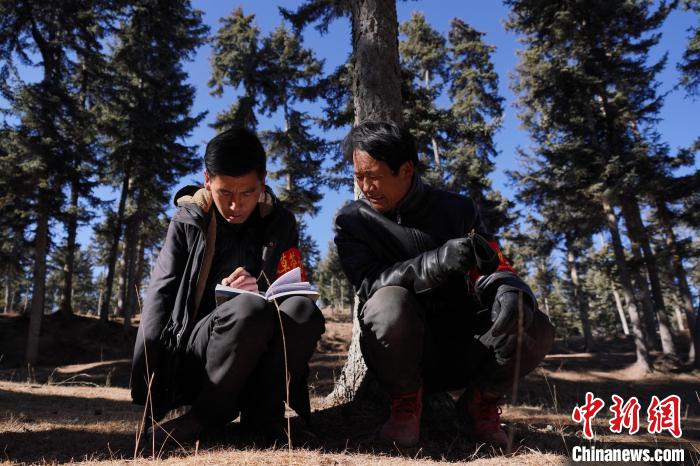 圖為桑杰加(左)和同事記錄巡查結(jié)果?！●R銘言 攝