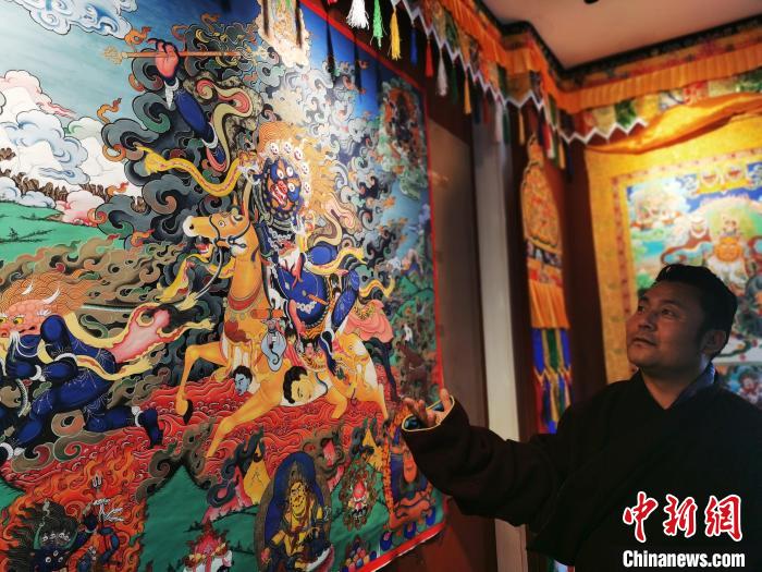 圖為久美尖措展示唐卡作品。　張?zhí)砀?攝