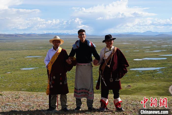 圖為一名留學(xué)生身穿自己國(guó)家的服飾和藏族民眾合影留念。　馬銘言 攝