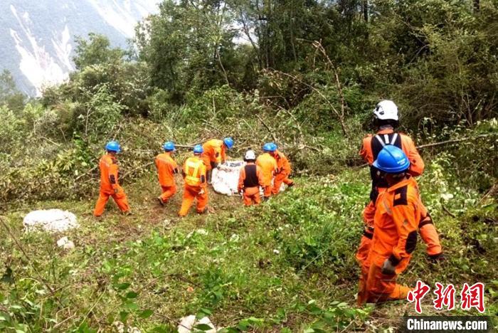 海拔1950米唐29號塔位搶險隊員正搬運直升機吊運上山的搶險材料?！⌒鞈c明 攝