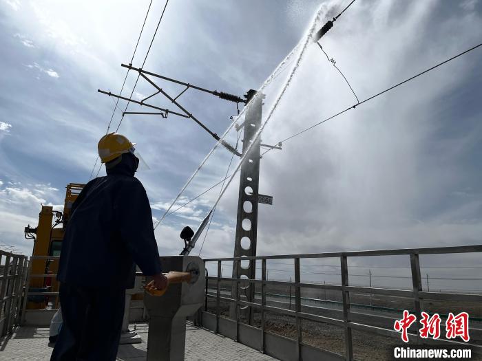 圖為高壓水槍的水柱沖洗絕緣子串。　高啟宏 攝