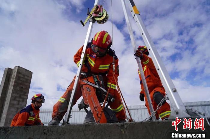 圖為地震實戰(zhàn)拉動現(xiàn)場，參演人員正在進行垂直救援項目?！∮駱湎拦﹫D