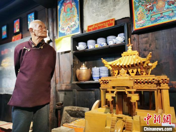 圖為古堡內(nèi)的藝人桑杰展示自己的雕刻作品。　張?zhí)砀?攝