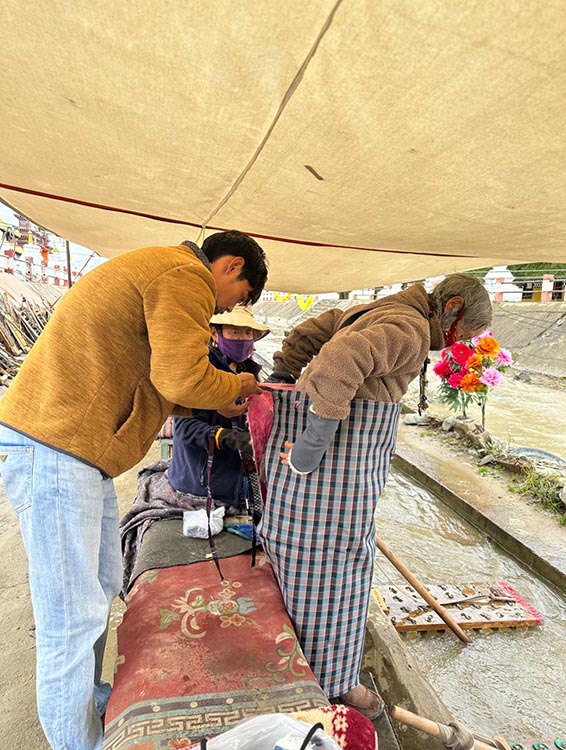 扎西奪爾登為路邊老人送去保暖圍腰。阿壩州文明辦供圖