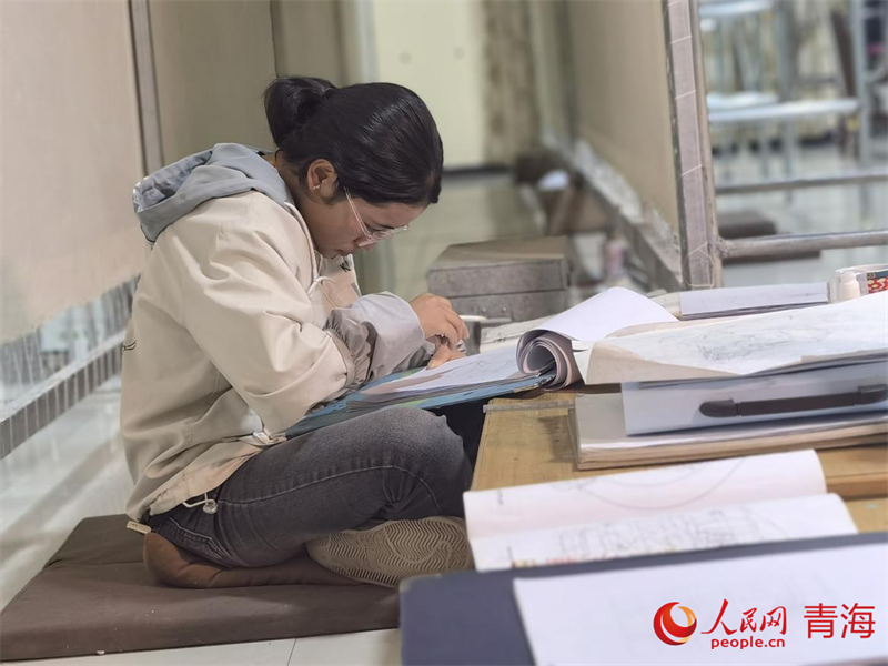 正在學(xué)習(xí)畫(huà)底稿的尕讓旺姆。人民網(wǎng) 陳明菊攝