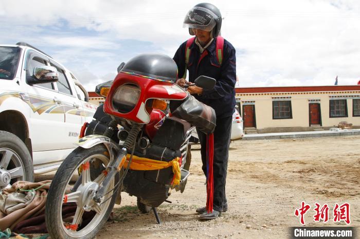 圖為白瑪準備騎摩托車巡湖?！≮w朗 攝
