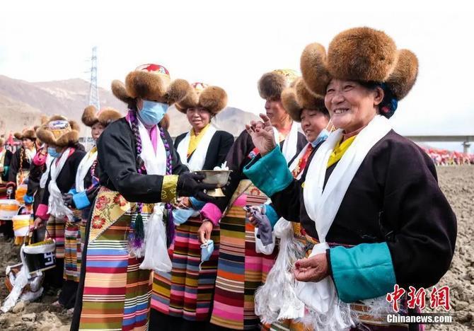 資料圖：西藏自治區(qū)拉薩市曲水縣才納鄉(xiāng)協(xié)榮村參加春耕儀式的村民互敬青稞酒。按照傳統(tǒng)，當?shù)卮迕裆碇?jié)日盛裝，舉行隆重的儀式，祈福一年的豐收。<a target='_blank' ><p  align=