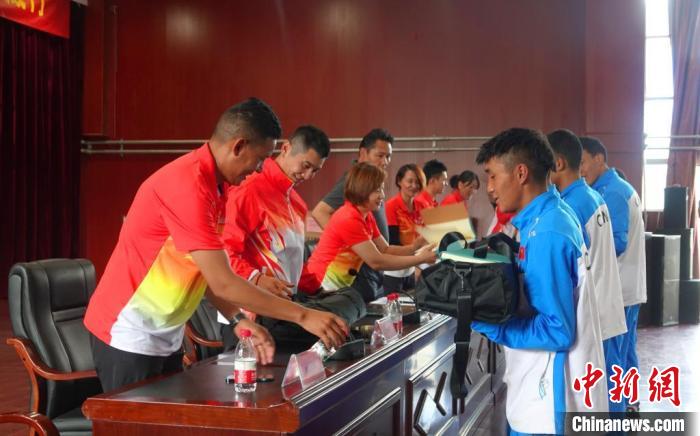 圖為世界冠軍們?yōu)槲鞑刈灾螀^(qū)體校的學(xué)生們送上暖心物資。　冉文娟 攝