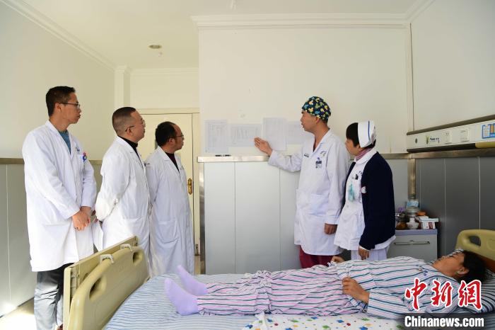 圖為何蔚副主任醫(yī)師(站右二)及團(tuán)隊(duì)術(shù)后對(duì)患者的肌肉訓(xùn)練、蛋白飲食等制定了每半日的康復(fù)計(jì)劃。　貢嘎來(lái)松 攝