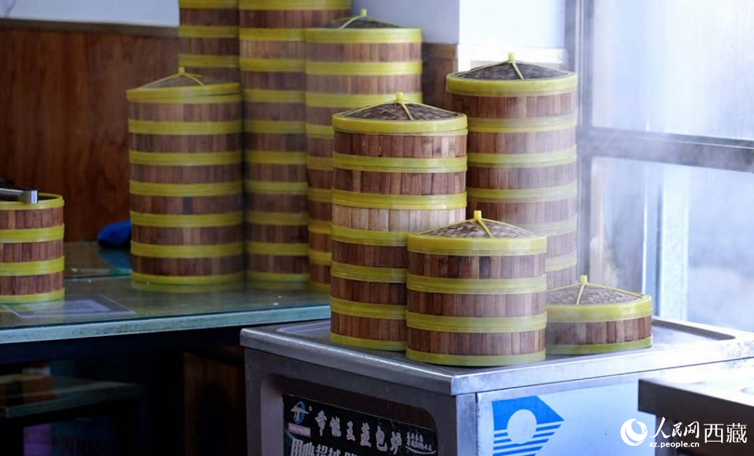電蒸箱上擺滿了多屜熱氣騰騰的包子。人民網(wǎng) 次仁羅布攝