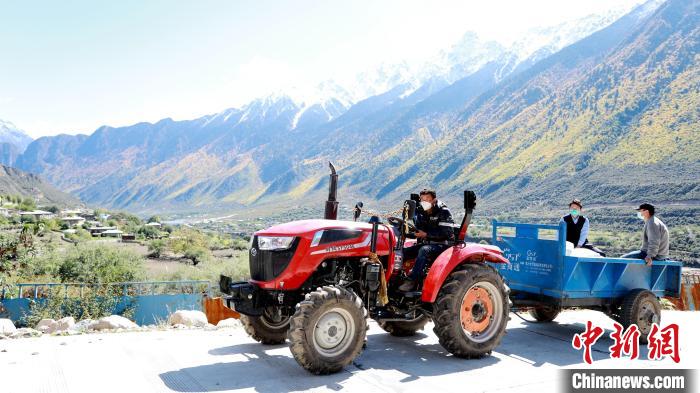 圖為工作人員將把加工完成的糌粑運送至村民手中?！〖卫杩h融媒體中心供圖