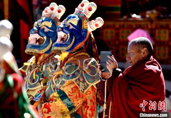 2月19日，正在拍攝跳神活動(dòng)的僧人?！±盍?攝