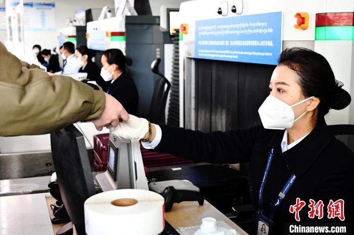 圖為機(jī)場(chǎng)工作人員為旅客辦理行李托運(yùn)?！≈芎?攝