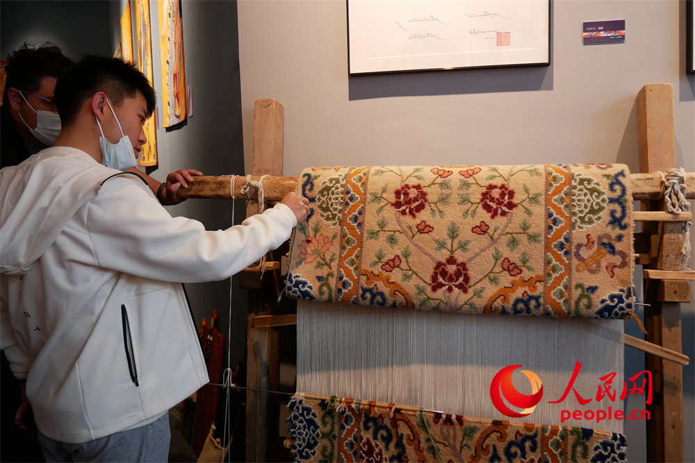 觀眾正在觀賞展出的藏毯。人民網(wǎng) 韋衍行攝
