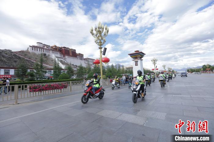 圖為比賽選手途經(jīng)布達拉宮?！∮文恋厍蚬﹫D