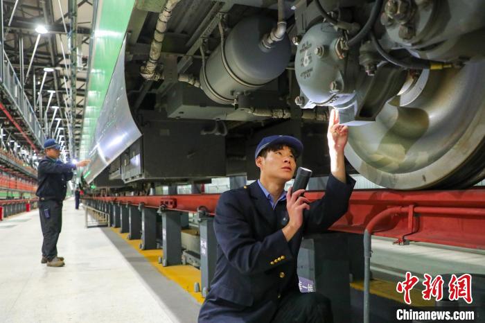 圖為工作人員檢查高原復(fù)興號(hào)?！≈軔傁?攝