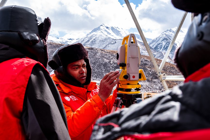 2023年11月30日，西藏自治區(qū)那曲市索縣榮布至丁青縣巴達(dá)35千伏線路工程負(fù)責(zé)人黃小洪（左二）現(xiàn)場開展線路弧測量教學(xué)。趙清鵬攝