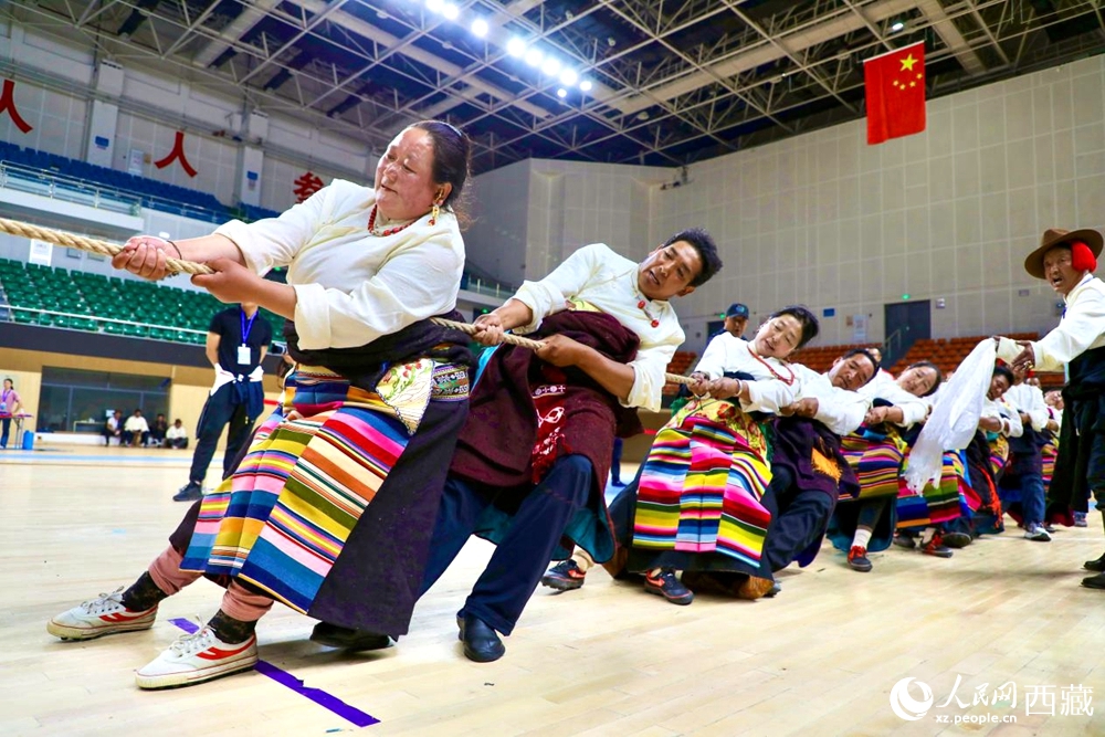 身著民族服裝的農(nóng)牧民選手在拔河比賽現(xiàn)場。