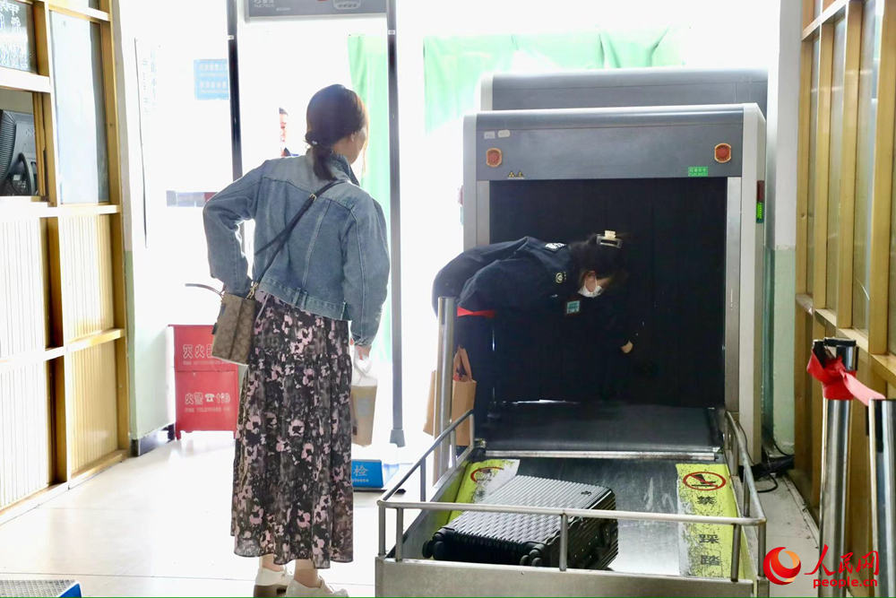 車站工作人員幫旅客提取行李。人民網(wǎng)記者 次仁羅布攝