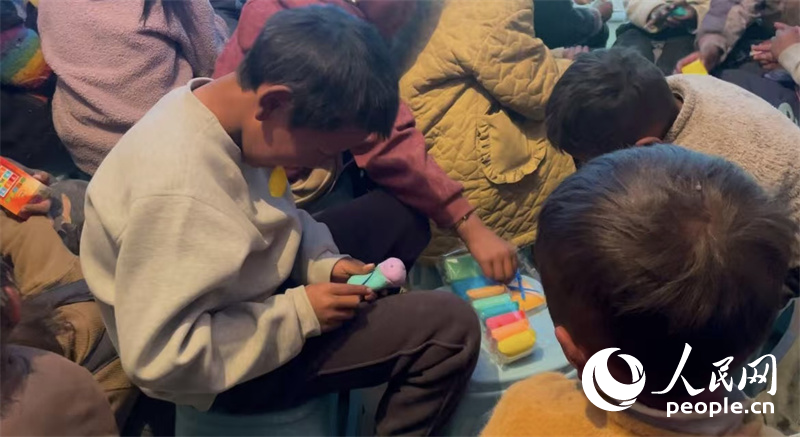 措果鄉(xiāng)塘仁村的孩子們正在用橡皮泥制作自己的情緒“小怪獸”。人民網(wǎng)記者 郝潔攝